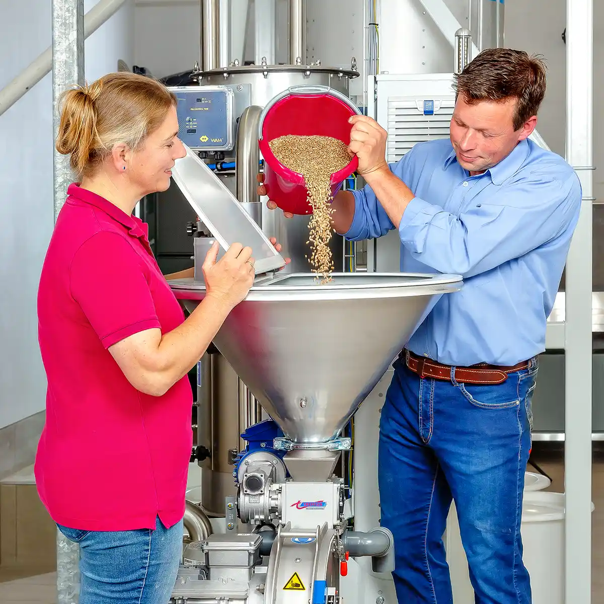 lohnaufbereitung - Bianca und Tillmann kippen gemeinsam Korn in die Kornmühle