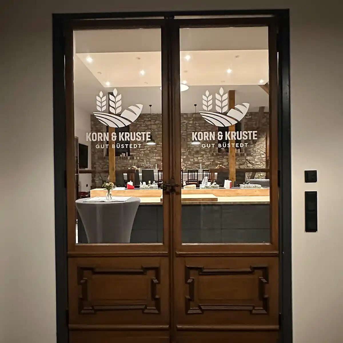 Tür mit Glas auf dem das Logo von Korn und Kruste zu sehen ist.