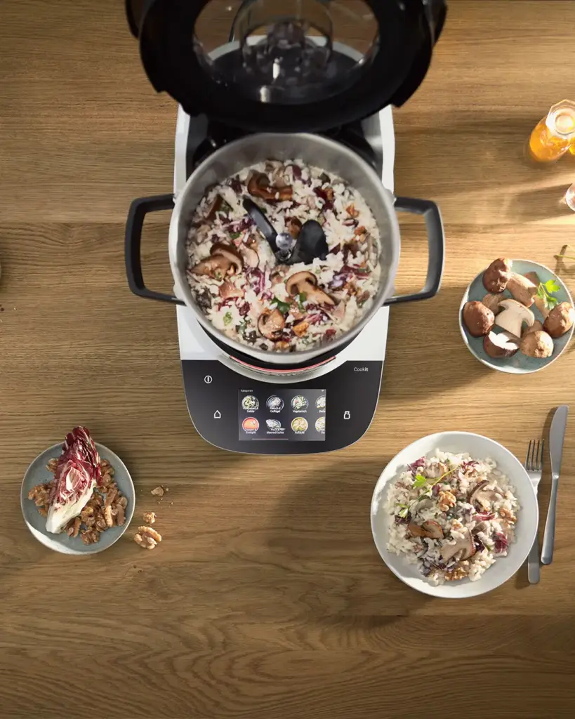 Blick von oben auf den Cookit von Bosch der auf auf dem Tisch steht, daneben Schalen mit Essen.