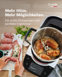 Cookit von Bosch steht auf dem Tisch, daneben rollen zwei Hände ein Stück Fleisch und im Cookit sind Fleischstücke